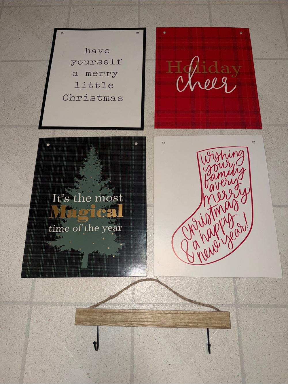 four holiday-themed hanging signs with a wooden poster hanger